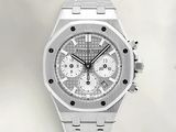 a close up of a silver watch on a white surface