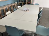 une table blanche et des chaises bleues dans une pièce