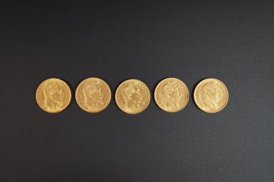 quatre pièces d'or sont disposées en ligne sur une surface noire