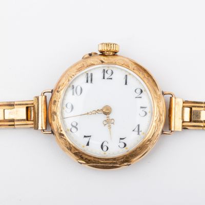 une image d'un gros plan d'une montre-bracelet sur une surface blanche