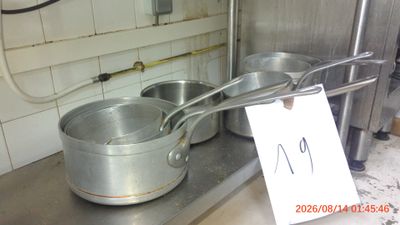 pots and pans on a counter in a kitchen with a price tag