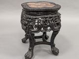 an ornately carved table with a marble top on a stand