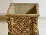 a small gold planter sitting on top of a glass table