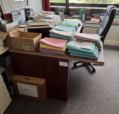un bureau sur lequel se trouvent de nombreuses boîtes et de nombreux papiers