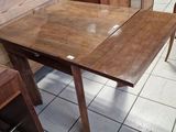 a table and chairs in a room with a wooden wall