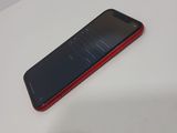 a red and black cell phone sitting on a white table