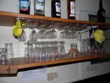une étagère en bois sur laquelle sont posés des verres à vin et des bouteilles