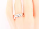 a woman ' s hand with a diamond ring on it