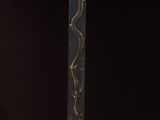 une sculpture noire et dorée sur laquelle est représenté un serpent