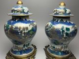 pair of blue and white vases with gold accents on stands