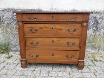 une commode en bois posée sur un sol en briques