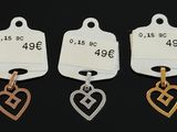 three tags with a heart and a cross on them on a black background