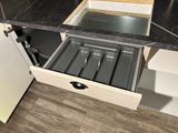 an open drawer in the middle of a kitchen counter