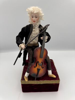 a figurine of a man with a cello on a box