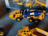 un tas de petits engins de chantier en jouets qui traînent par terre