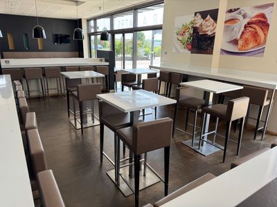 de nombreuses tables et chaises dans un restaurant doté de nombreuses fenêtres