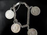 un gros plan d'un bracelet à maillons orné de pièces de monnaie