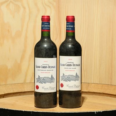 two bottles of wine sitting on top of a barrel