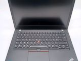 the laptop is open on a white surface with a red button on the keyboard