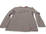un t-shirt gris sur lequel figure la signature d'un homme