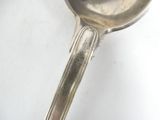 a silver spoon with a handle on a white surface
