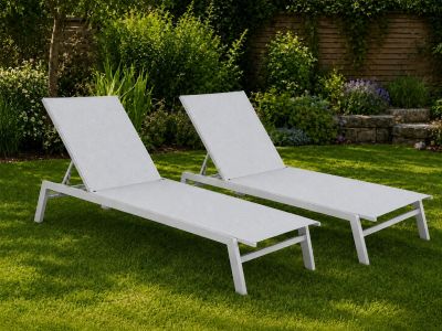 two white chaise loungers sitting in the grass in a garden