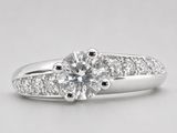 une bague de fiançailles en or blanc sertie d'un diamant rond taille brillant
