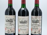 three bottles of wine are lined up on a white surface
