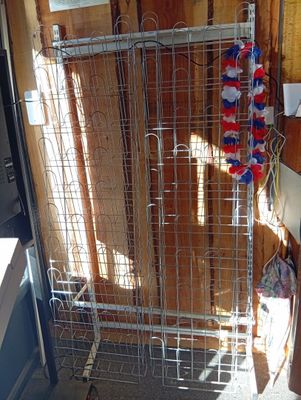 une cage métallique à laquelle sont suspendus tout un tas d’objets