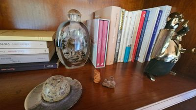 une étagère sur laquelle se trouvent des livres, un vase et d'autres objets