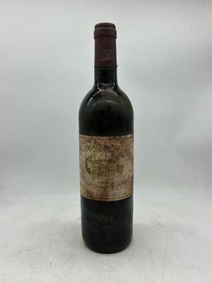 une vieille bouteille de vin posée sur une table blanche
