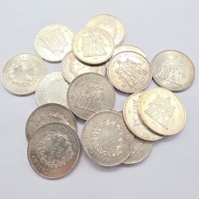 quelques pièces d'argent posées sur une surface blanche, sur fond blanc