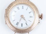 a gold watch with roman numerals on the face