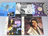 Plusieurs albums de styles musicaux variés sont disposés sur une table