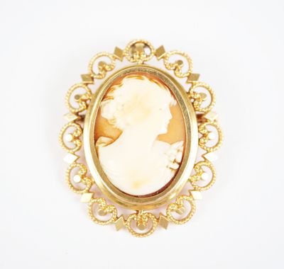 a close up of a gold broochle with a woman ' s profile in it