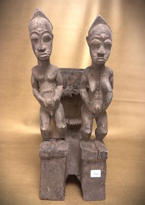 statue représentant deux personnes assises sur une boîte posée sur une table