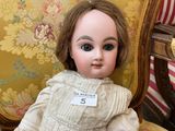 a doll that is sitting on a chair with a tag on it