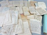 une pile de vieux papiers posée sur une table, à côté d'un rouleau de papier