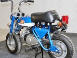 a small blue motorcycle with a black seat and a red light on it