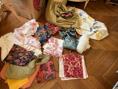 a pile of cloths on the floor next to a chair