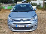 a small silver car parked in a lot with other cars in the background