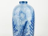 a blue and white vase sitting on a white surface