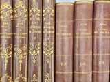 several old books are lined up on a shelf in a library