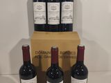 six bottles of red wine sit in front of a cardboard box