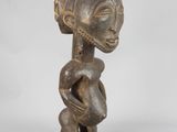 a wooden statue of a woman holding a baby