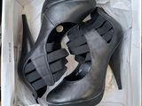 black high heeled shoes in a box on top of boxes