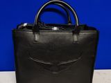 a black leather handbag with a winged design on the front
