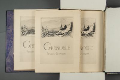 trois livres ouverts posés sur une table, sur lesquels figurent des illustrations