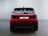 the rear end of a red car in a white room