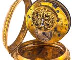 a gold pocket watch inside of it on a white surface
